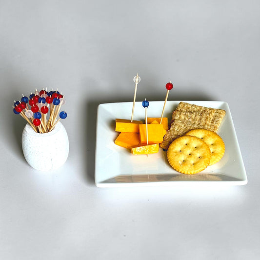 Plate of cheese and crackers with red, white and blue decorative toothpicks
