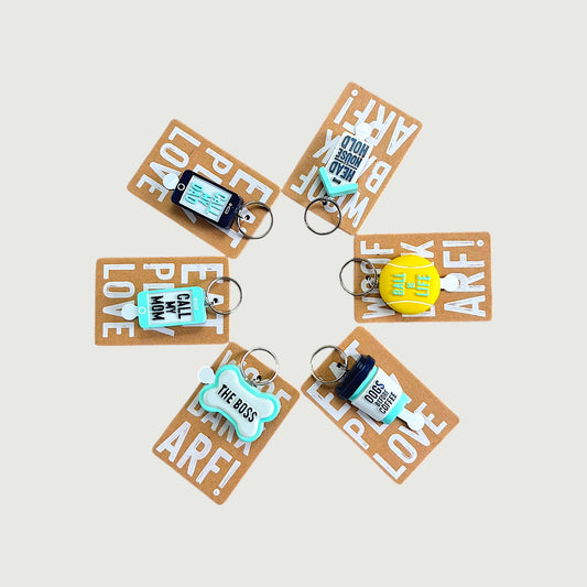 Set of keychains with humorous text on brown cards against a light background