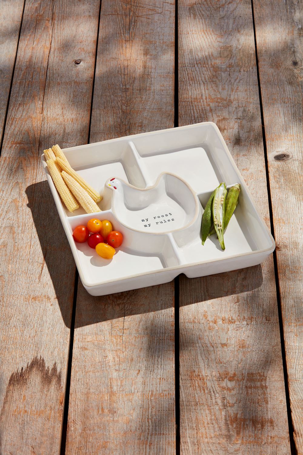 White divided plate with vegetables on a wooden surface