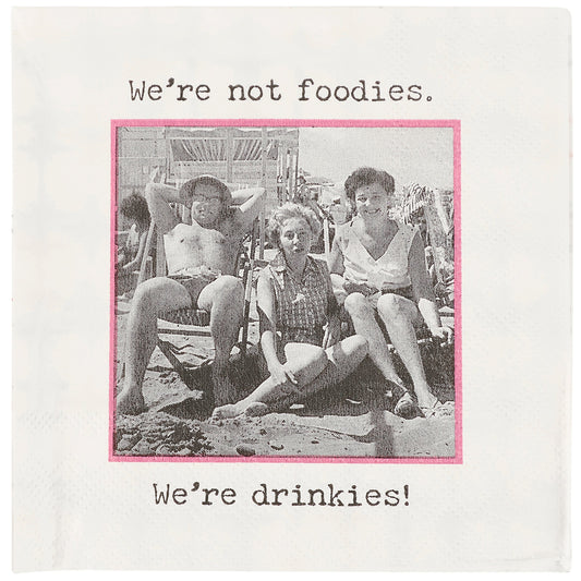 Vintage photo on a napkin of people at a beach with text 'We're not foodies. We're drinkies!' on a white background.