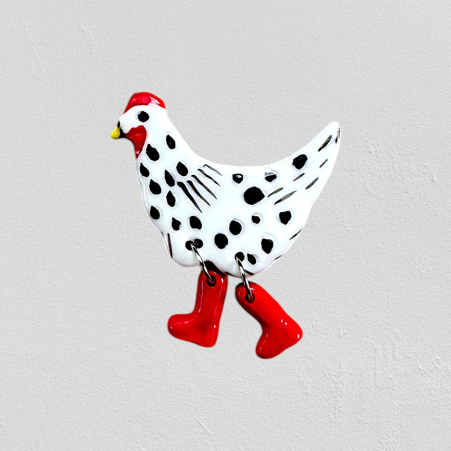 Decorative chicken figure with black spots and red rain boots 