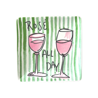 Two wine glasses with pink liquid and 'Rosé All Day' text on a green striped appetizer plate