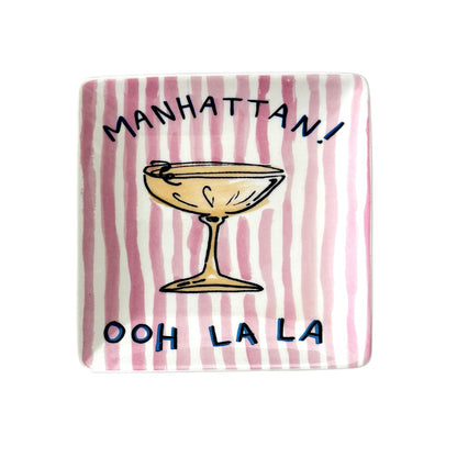 Rectangular plate with a striped pattern and text 'Manhattan! Ooh La La' on a pink 