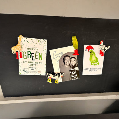 Decorative magnets on a blackboard with birthday invitations and a photo