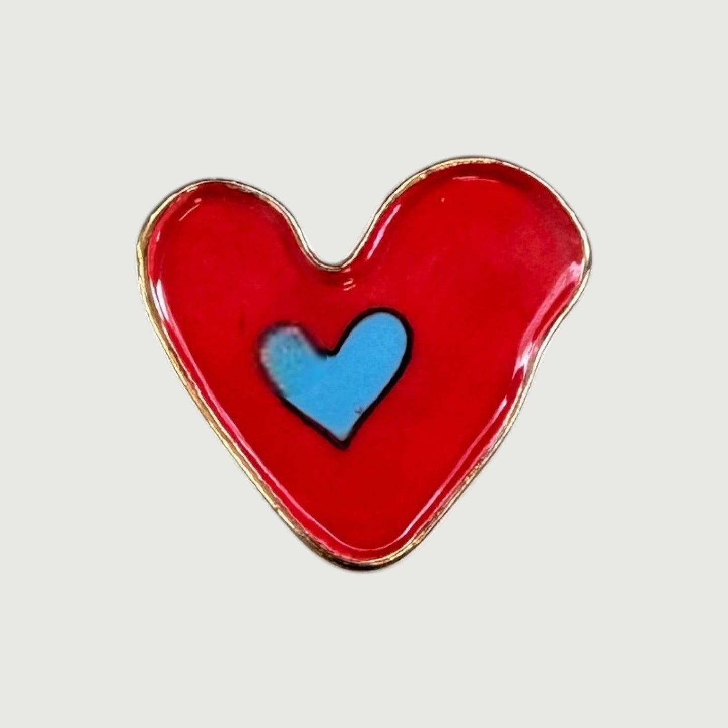 Heart-shaped magnet with a red exterior and blue interior heart.