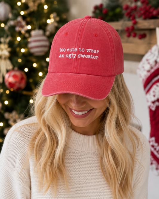 Person wearing a red cap with humorous text in front of a decorated Christmas tree.