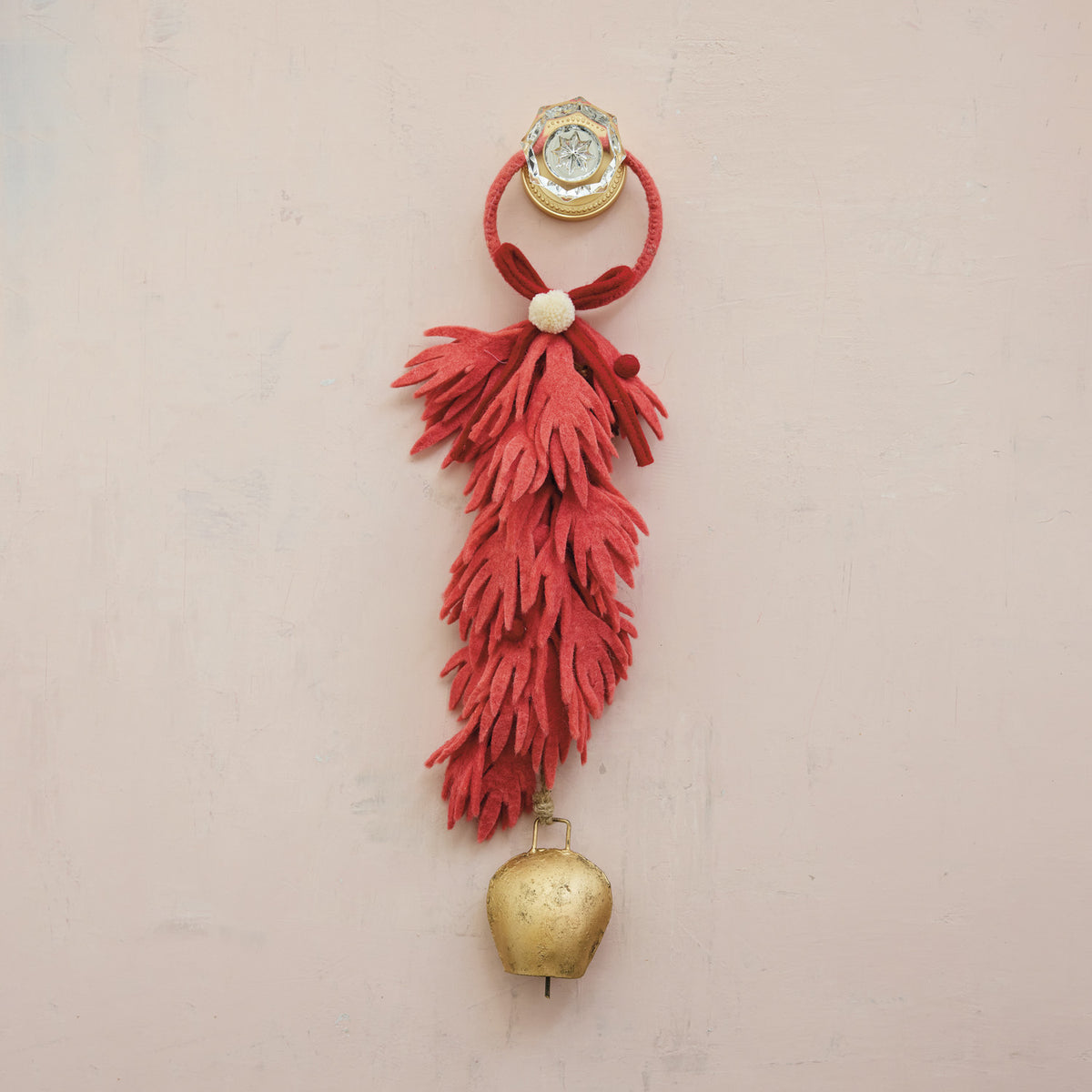 Decorative wall hanging with coral red tassel and gold bell 