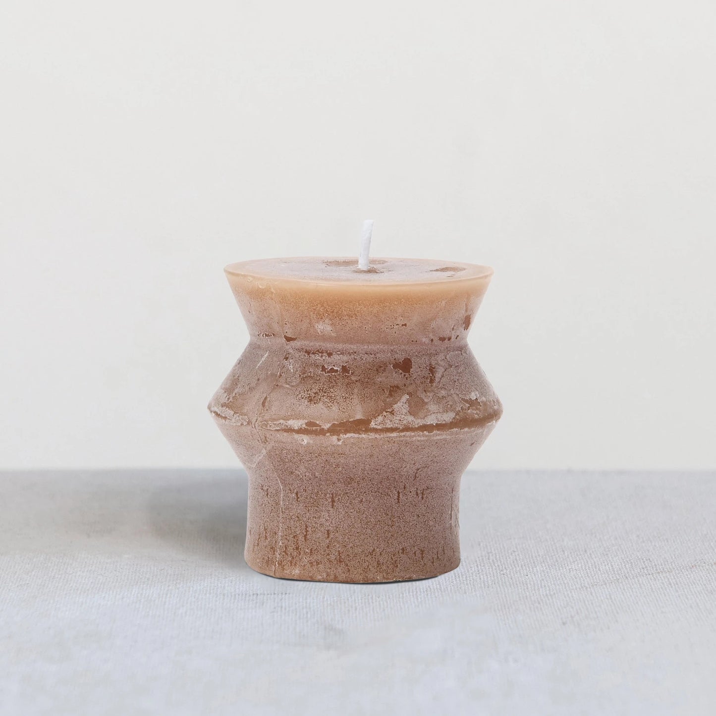 Light brown colored candle with sculptured design